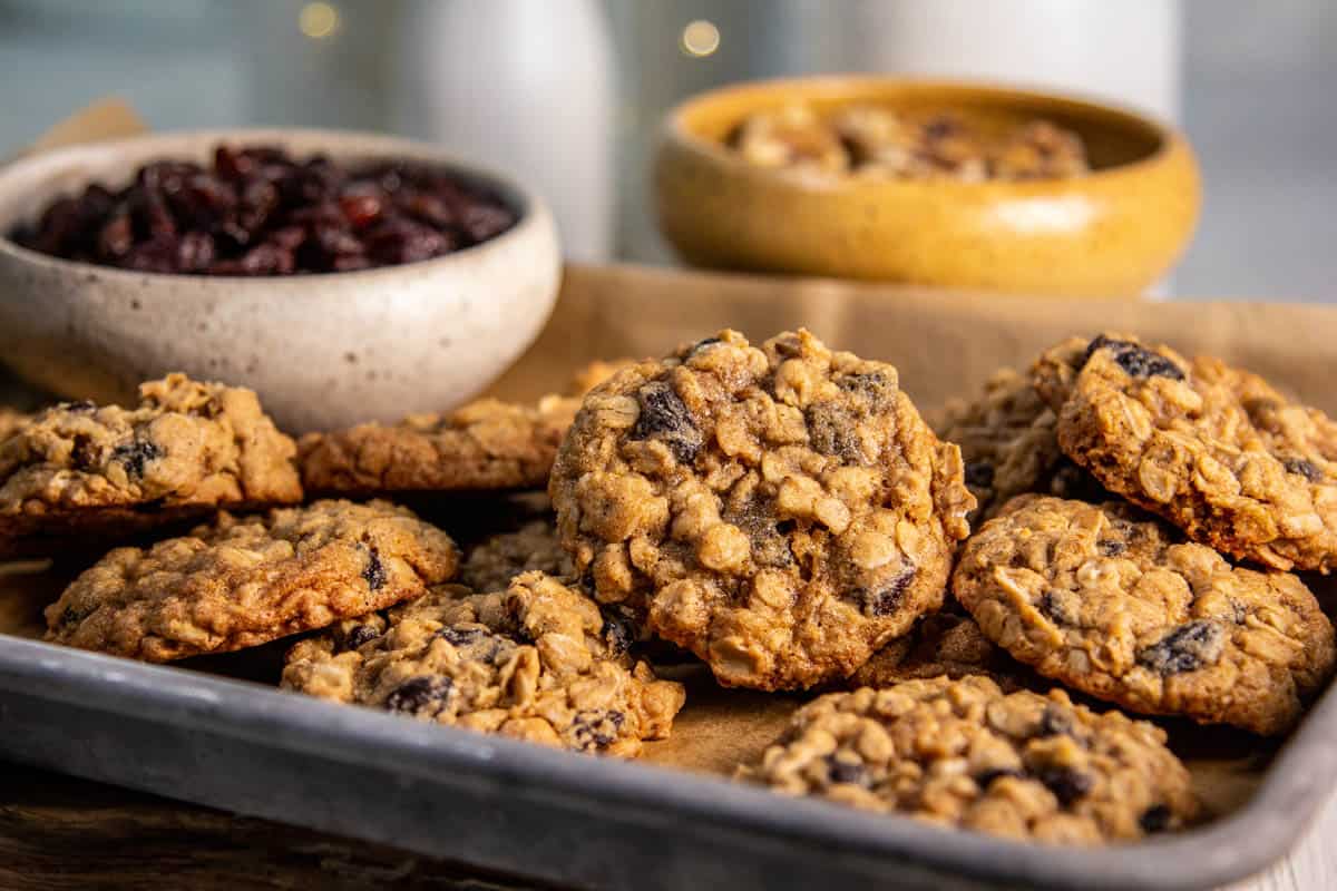 A sheet pan full of Raisin Oatmeal Cookies with twinkle lights in the background.