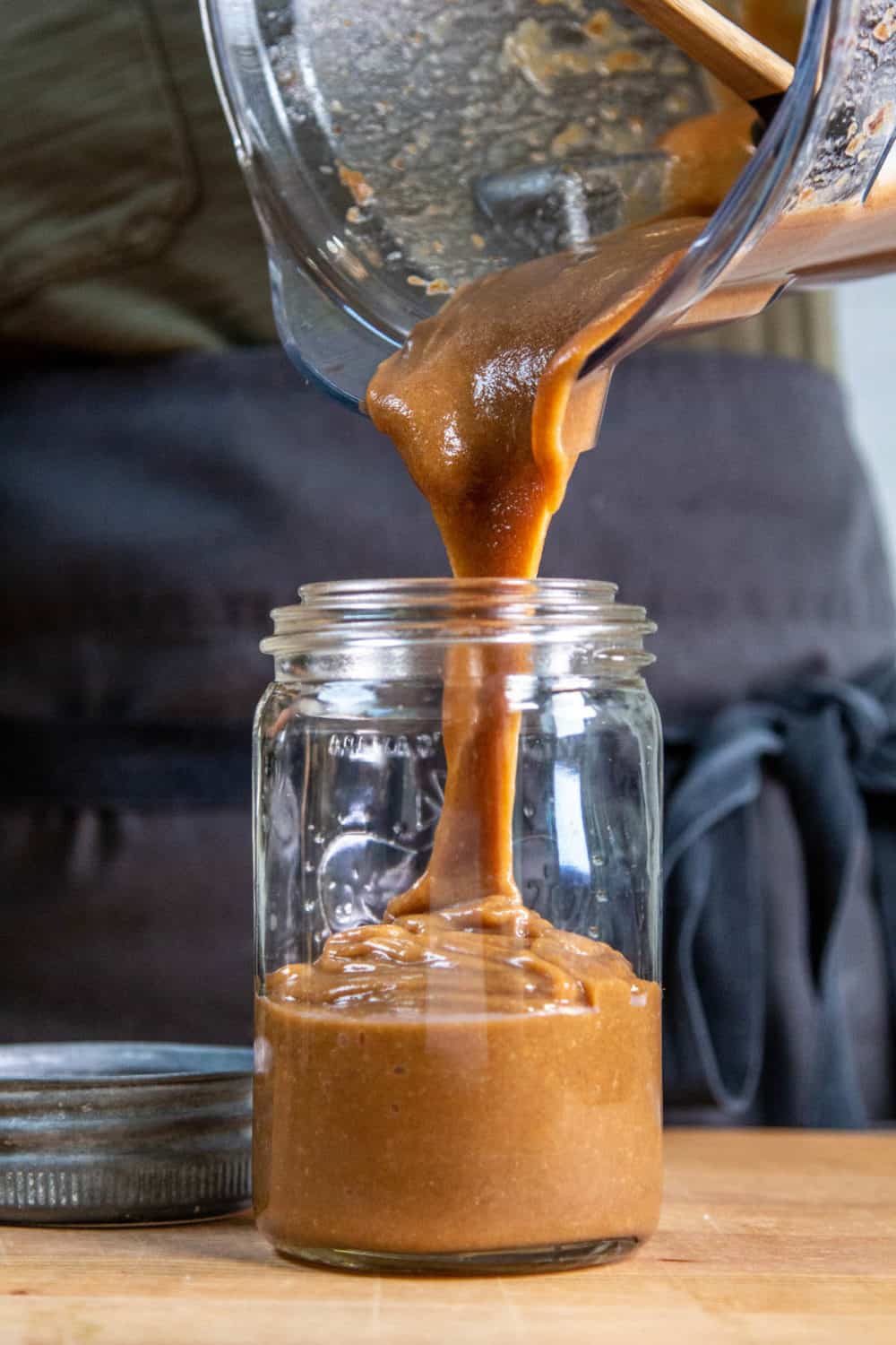 Date caramel being poured into a jar.