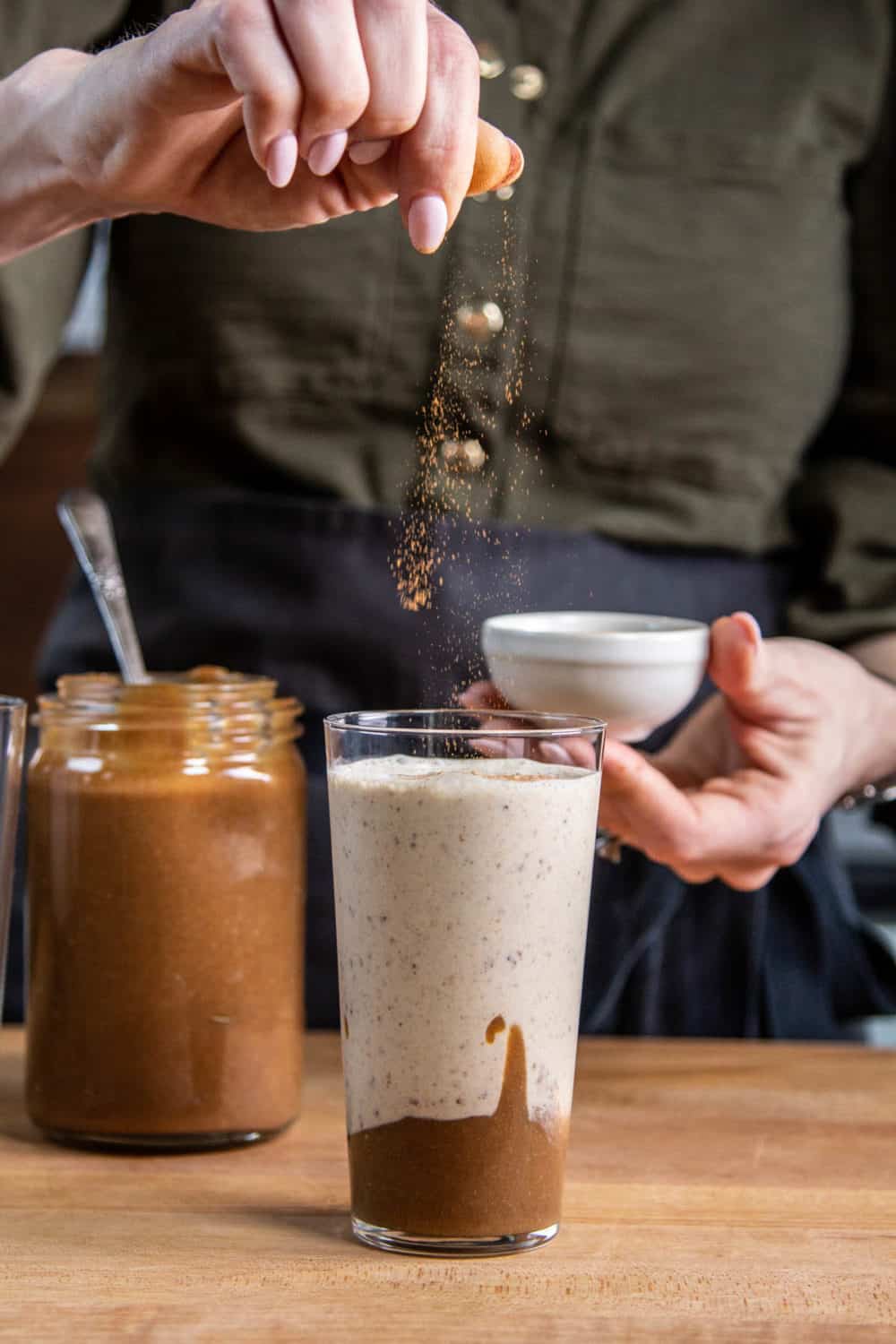 Sprinkling cinnamon on a date shake,