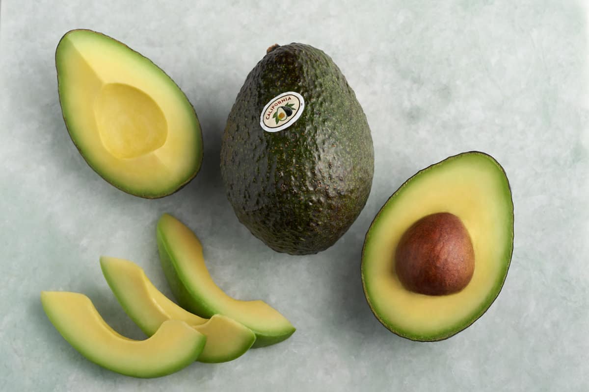 how avocados are grown: Avocado cut in half to show pit (or seed)