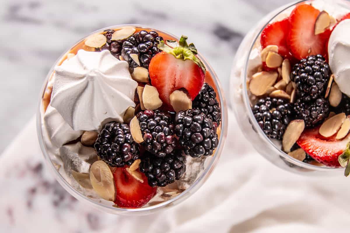 Top down view of two eton mess made with blackberries and strawberries.