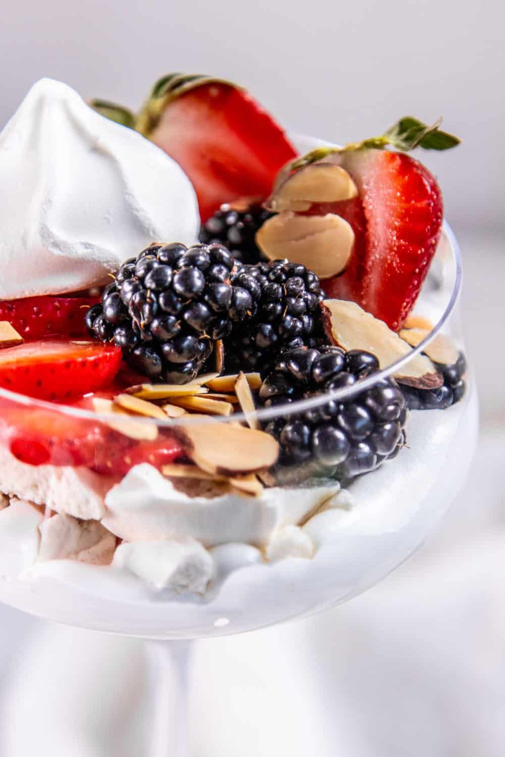 Side view of an eton mess in a glass coupe.