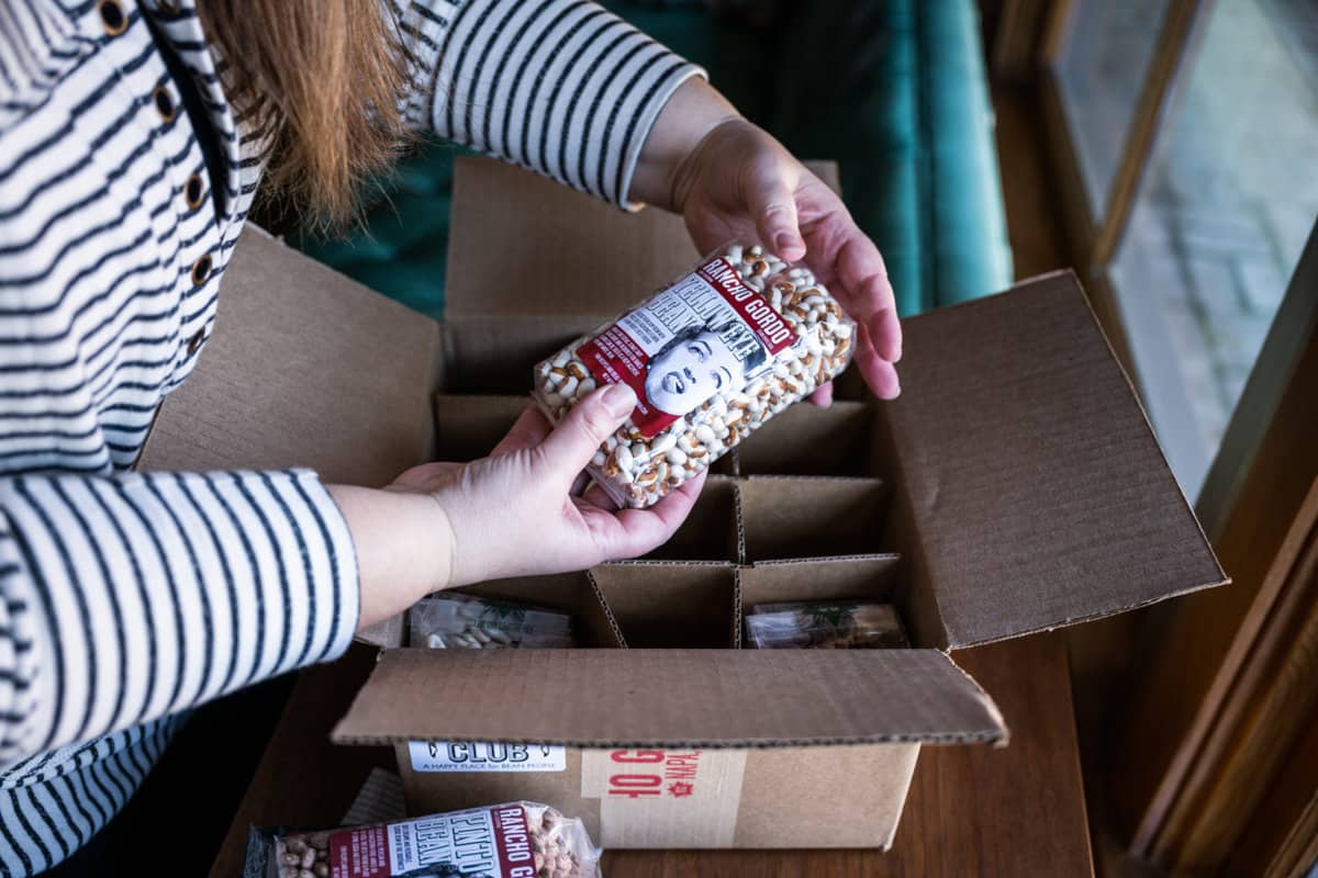 Woman opening the quarterly Bean Club Box from Rancho Gordo.