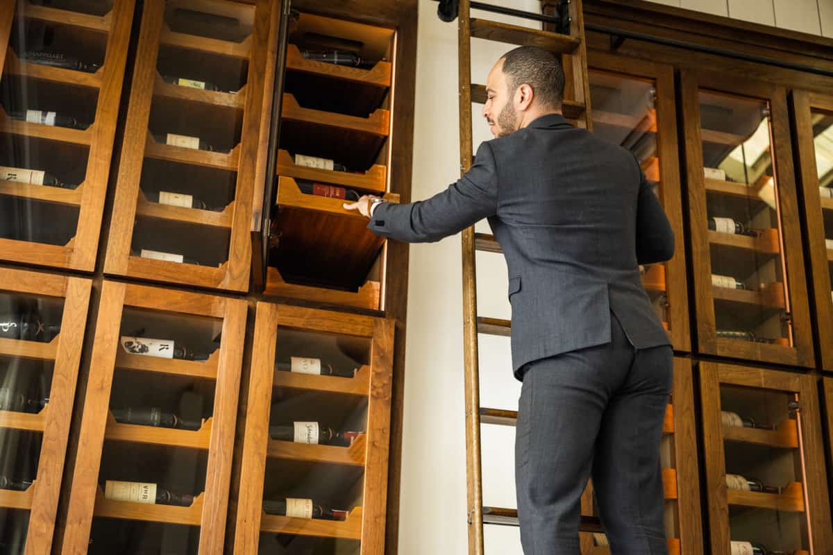 Vincent Morrow, Wine Director at Press grabbing a bottle from their extensive collection of California Wines
