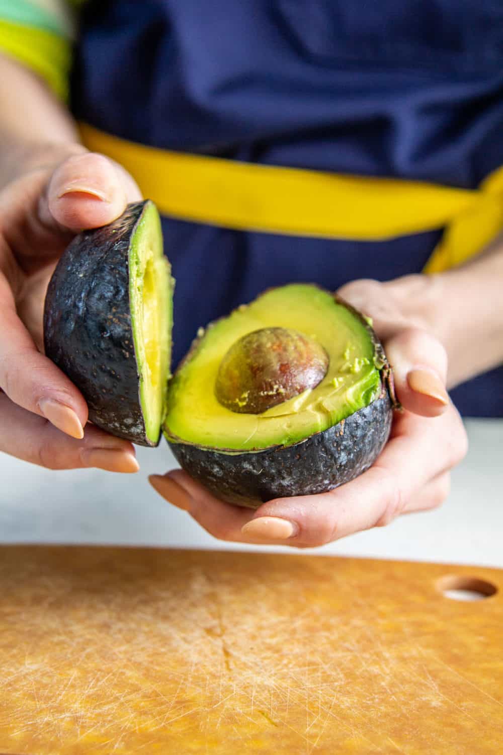 Opening a sliced avocado.
