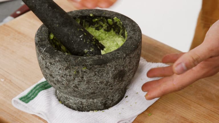 using a mortal and pestle to make aioli