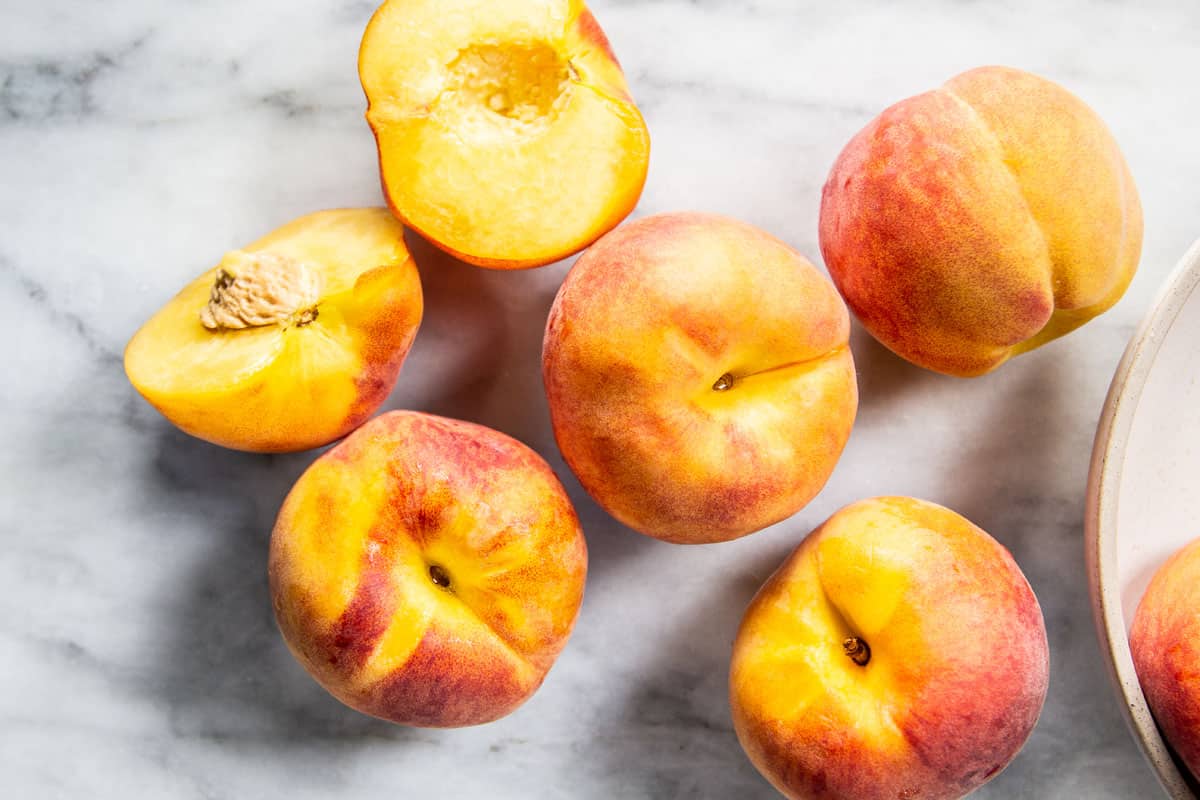 Fresh peaches on a marble slab.
