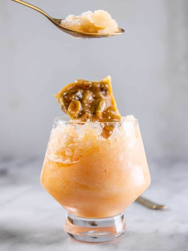 Cantaloupe granita shown on a golden spoon.