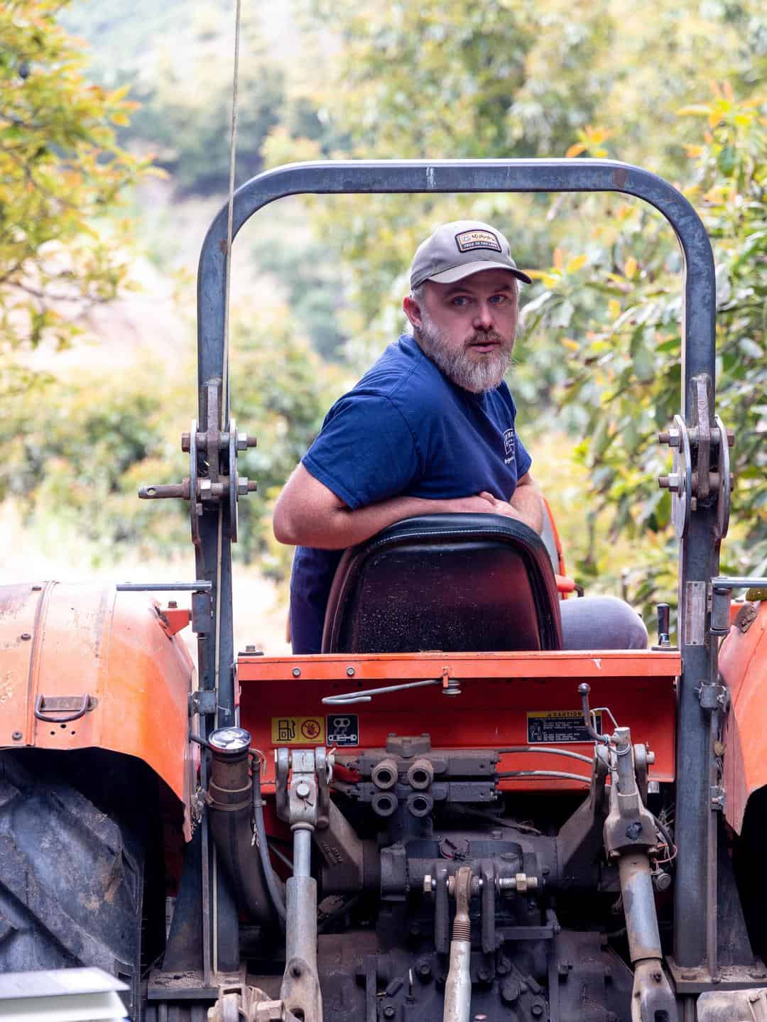 Spencer Steed driving a tractor through his avocado orchard