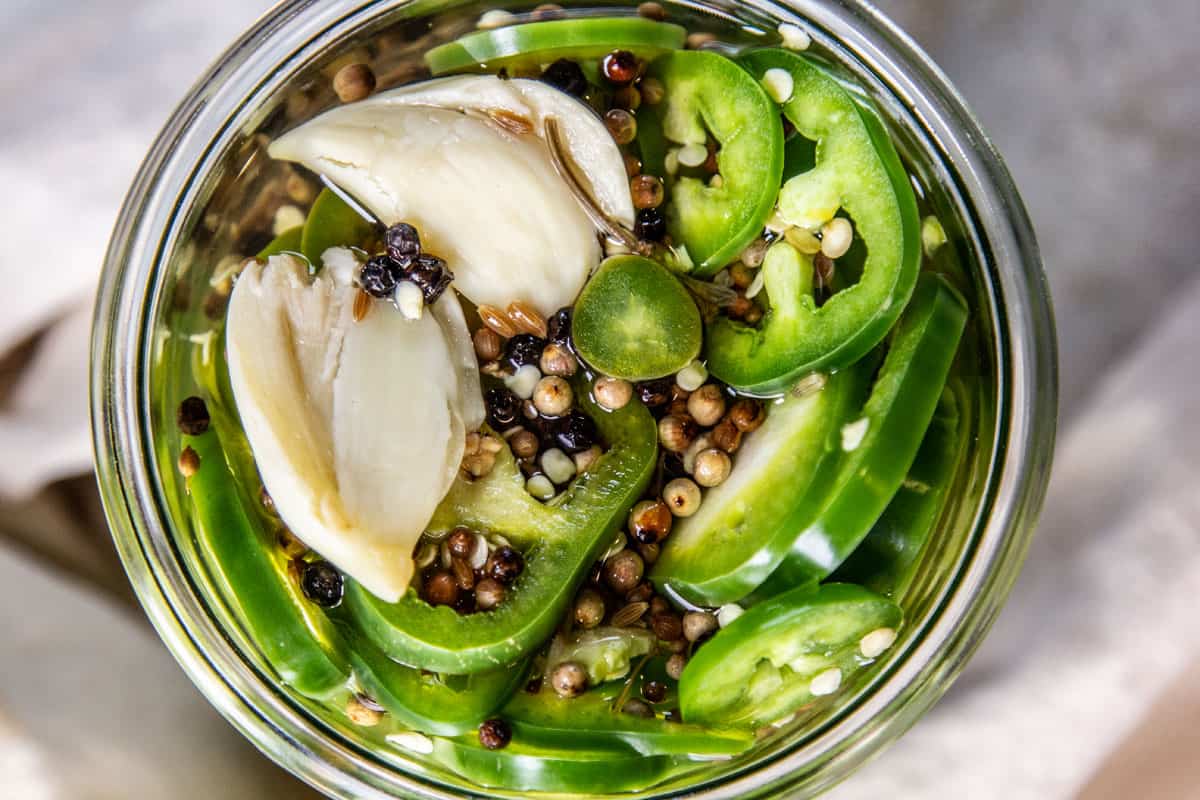 Looking down into a jar of pickled peppers.