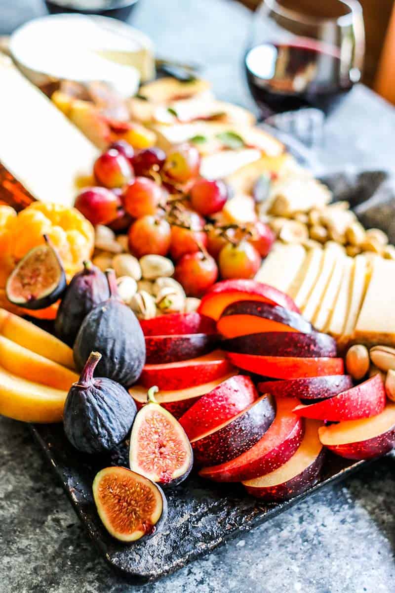 cheeseboard with pluot, fig and grapes