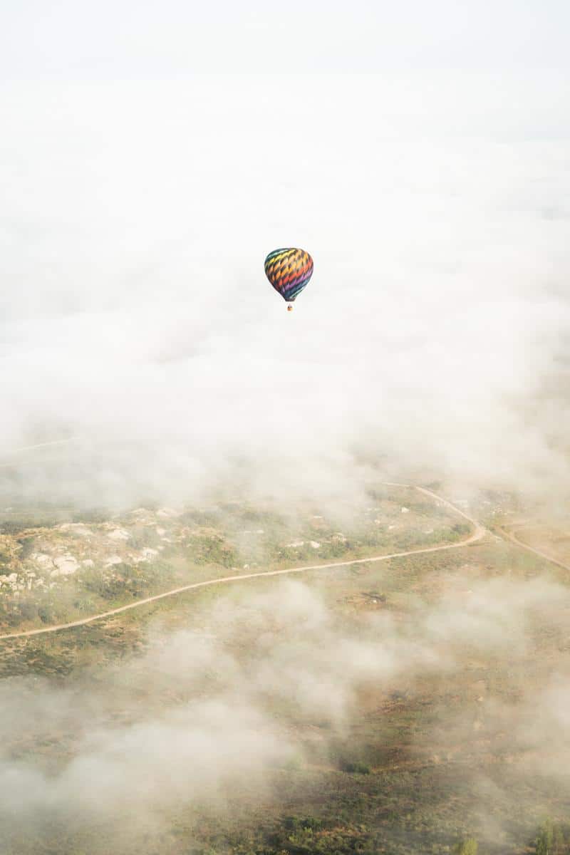 Hot air balloon floating in clouds in temecula valley