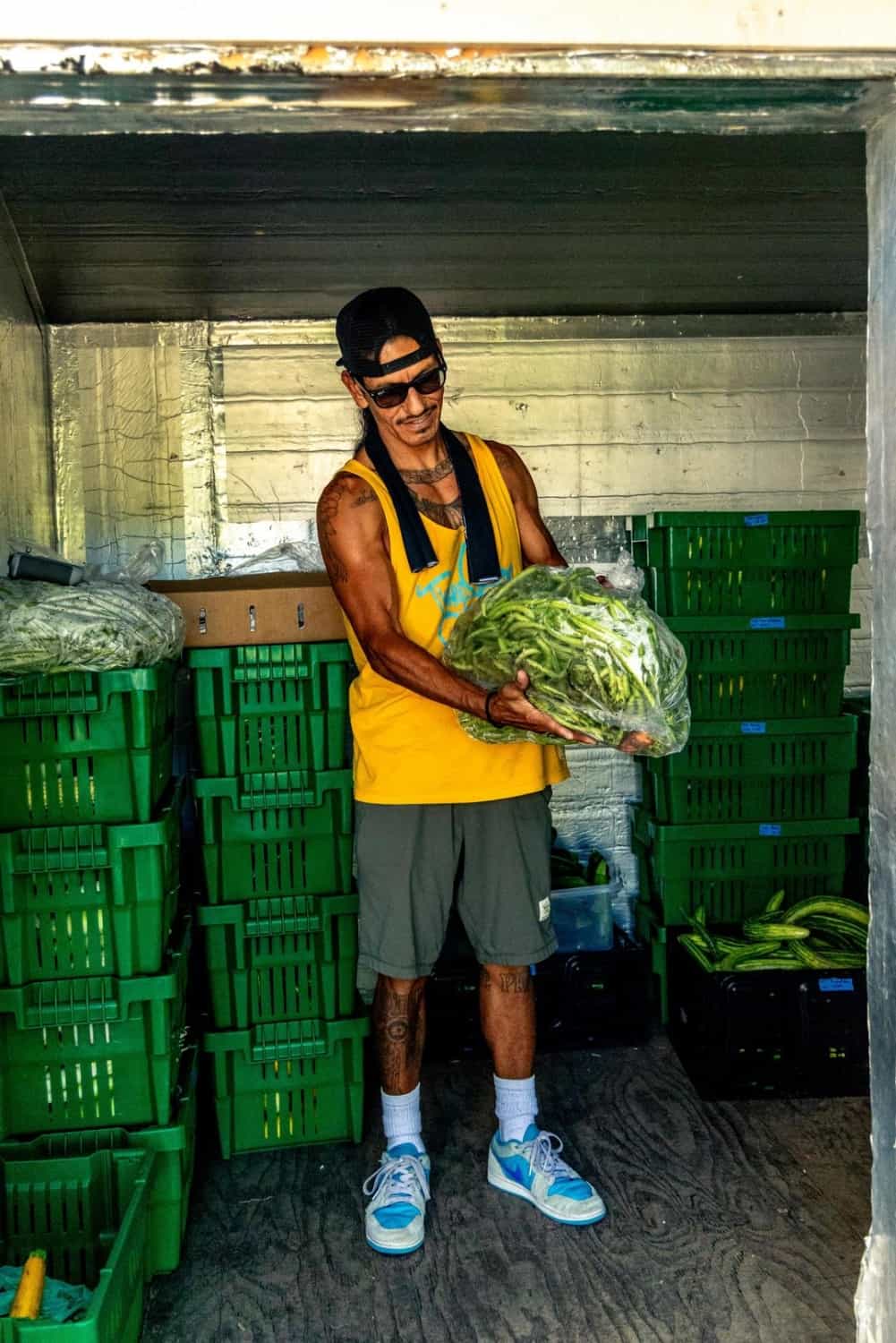 Alfred showing off freshly harvested green beans stored in his cooler
