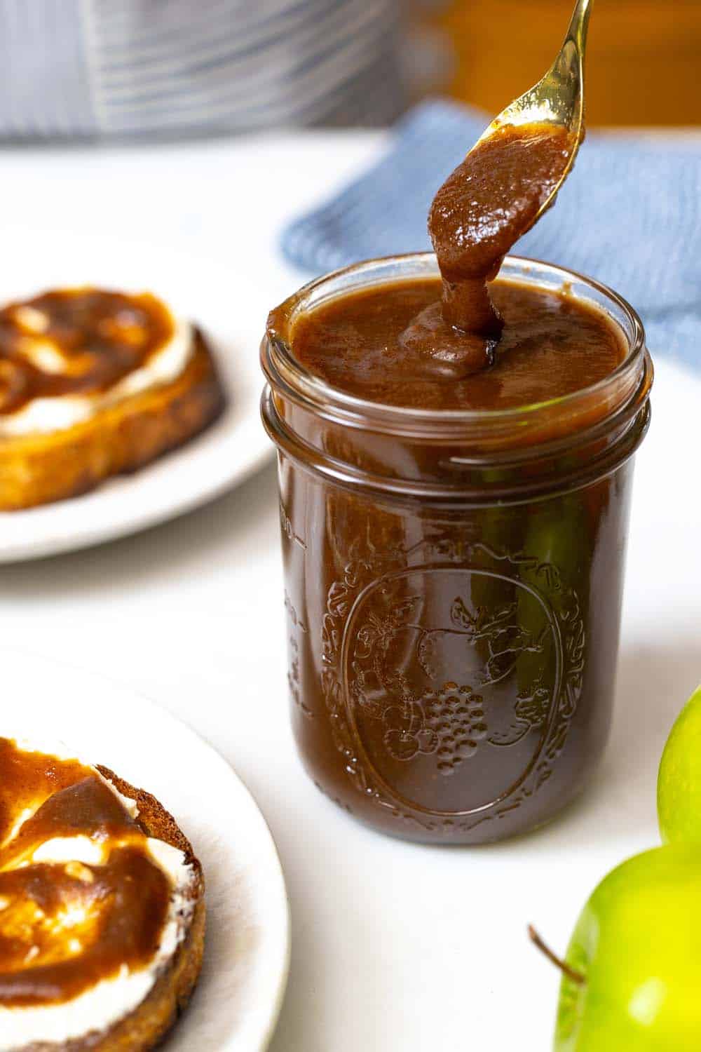 Apple butter in a jar being served on toast