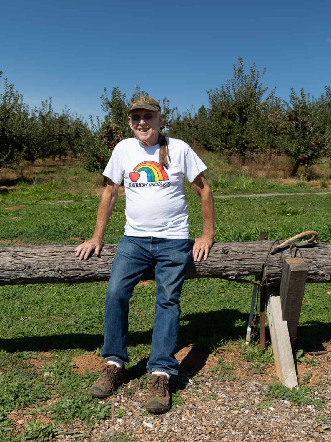tom heflin sitting on a fence at rainbow orchards