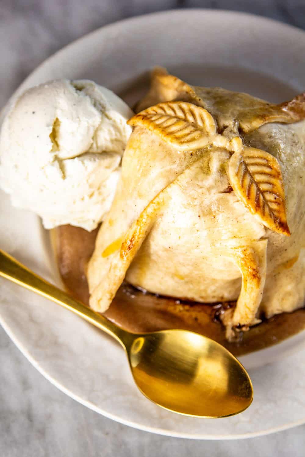 An apple dumpling with a scoop of ice cream.