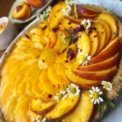 no bake peach tart garnished by chamomile flowers