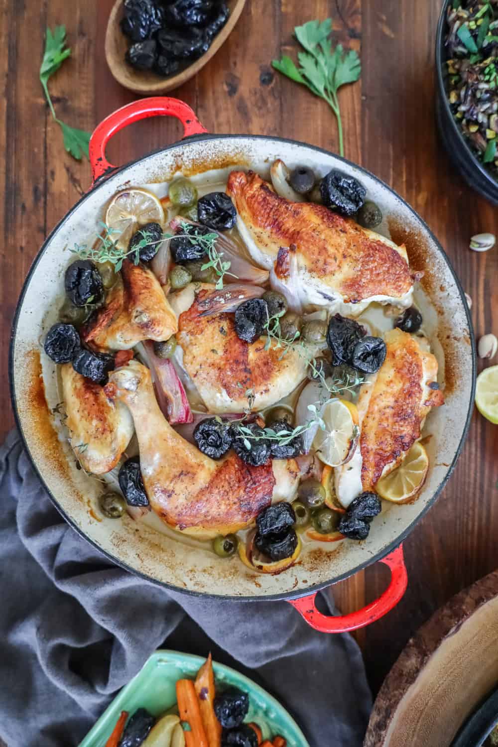 flat lay of roasted chicken with citrus and prunes in a pan