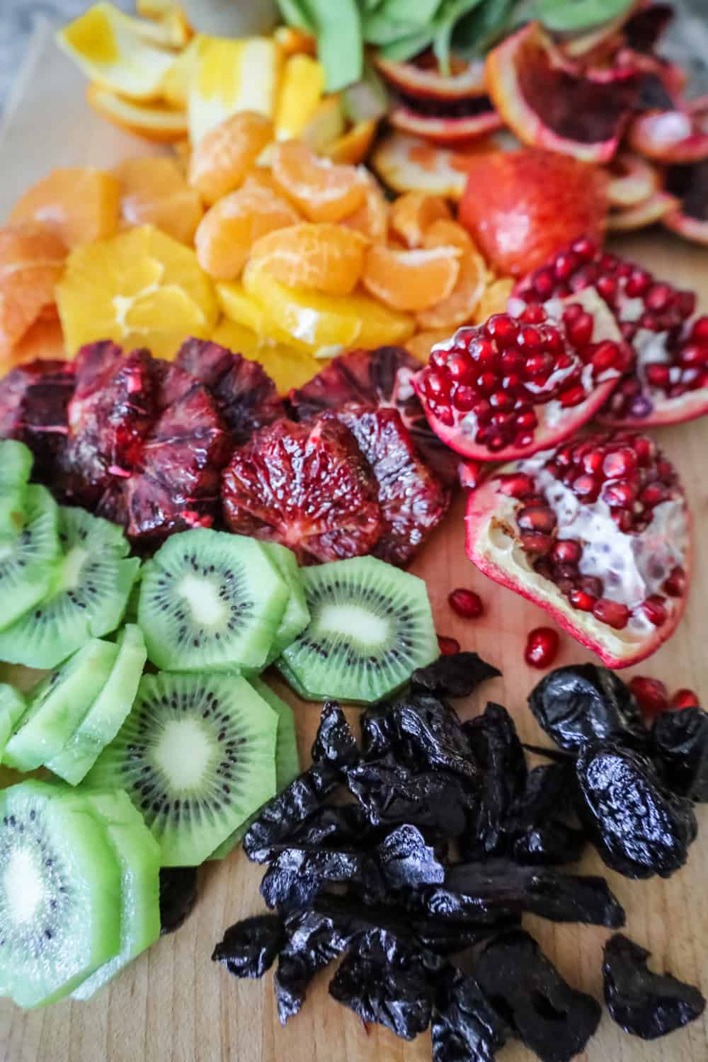 sliced citrus, prunes and kiwifruit on a platter