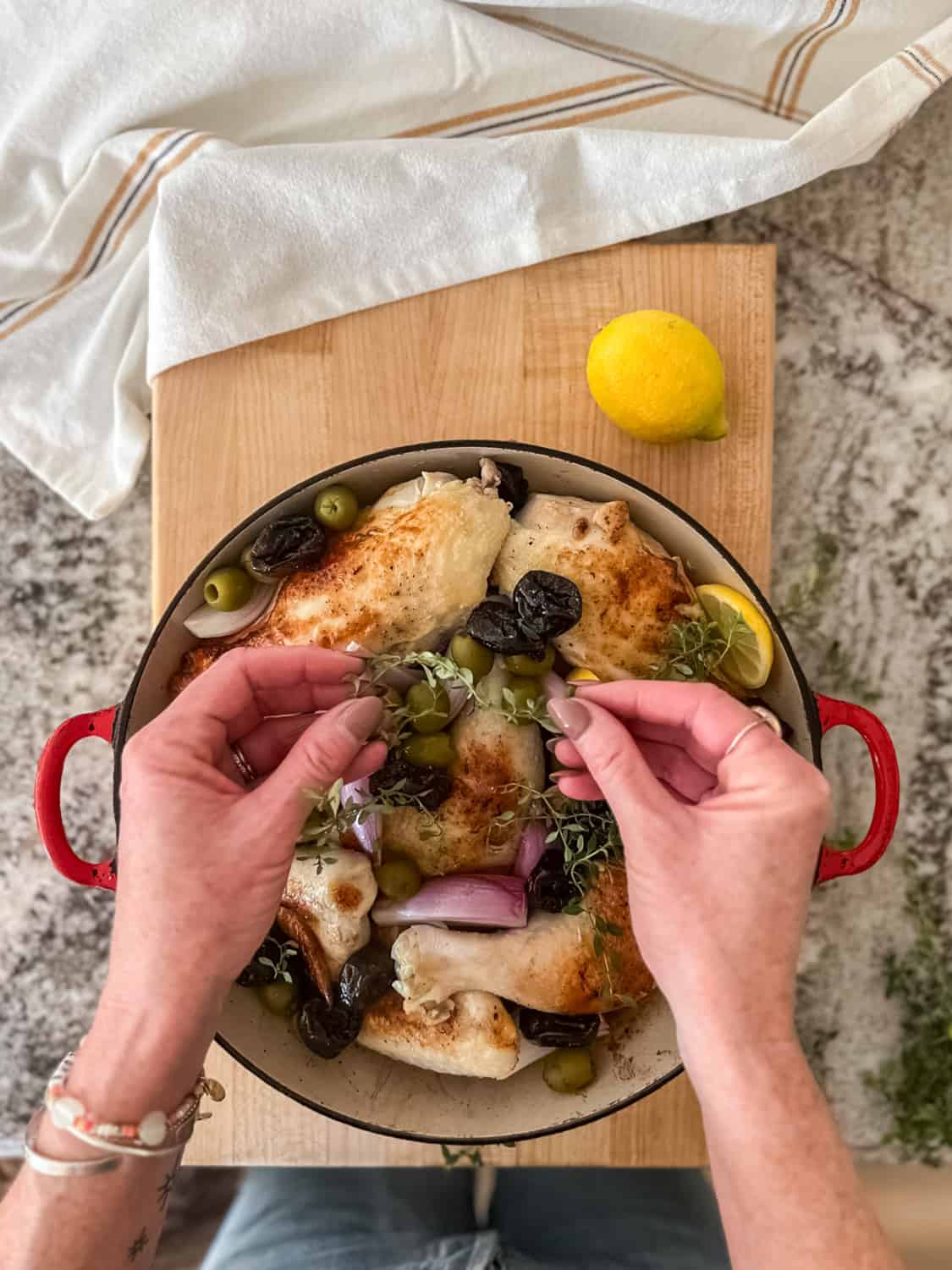 woman adding thyme to the pan