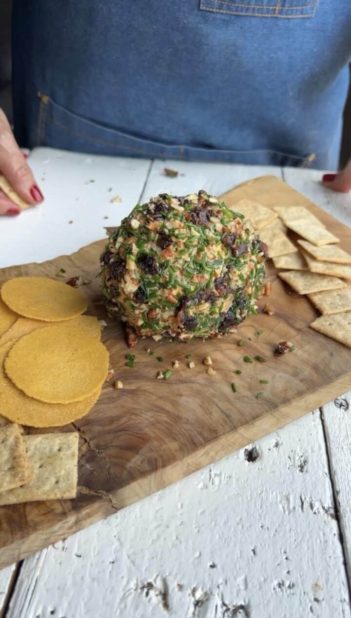 cheeseball on a wooden board with crackers