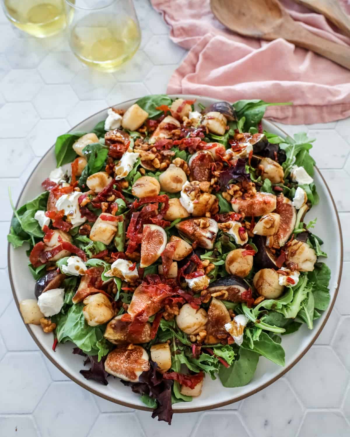 Fig Salad with scallops on a plate with a glass of wine