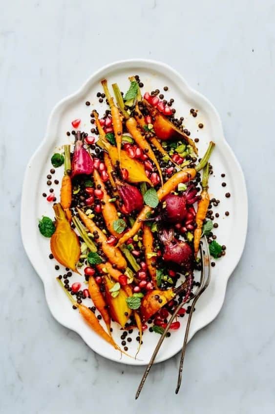 Roasted carrots and beets with ghost pepper and lentils on a platter - vy tran