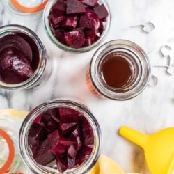 Looking down on jars full of diced and sliced roasted beets ready to be pickled.