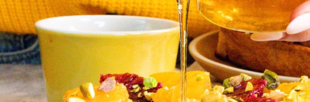 Honey being drizzled over a piece of Orange Cinnamon Toast with Honey.