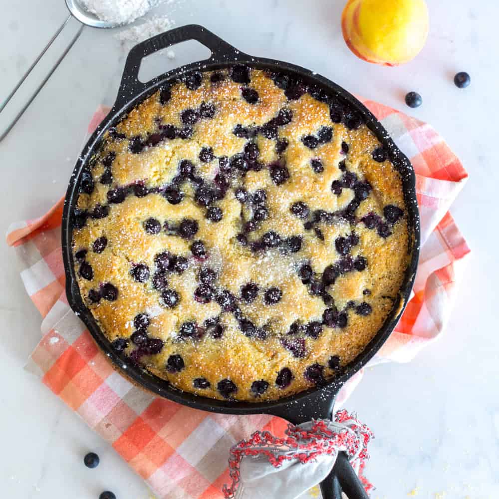blueberry cornmeal skillet cake in a black cast iron skillet