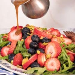 Mixed Berry Fruit Salad with vinaigrette being poured over the top.