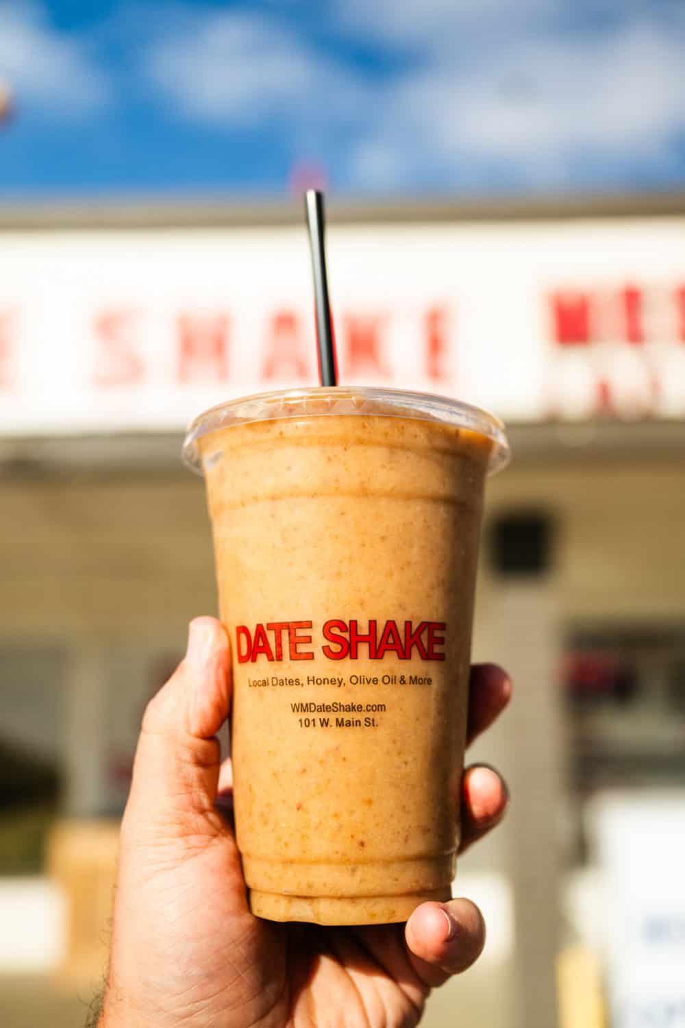 Hand holding a date shake. If you're in East Jesus, be sure to get a Date Shake! Nearby Coachella is the date capital of the nation! 