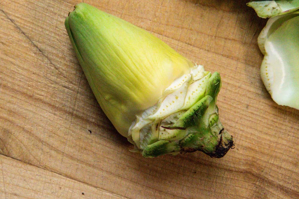Peeling petals from baby artichoke.