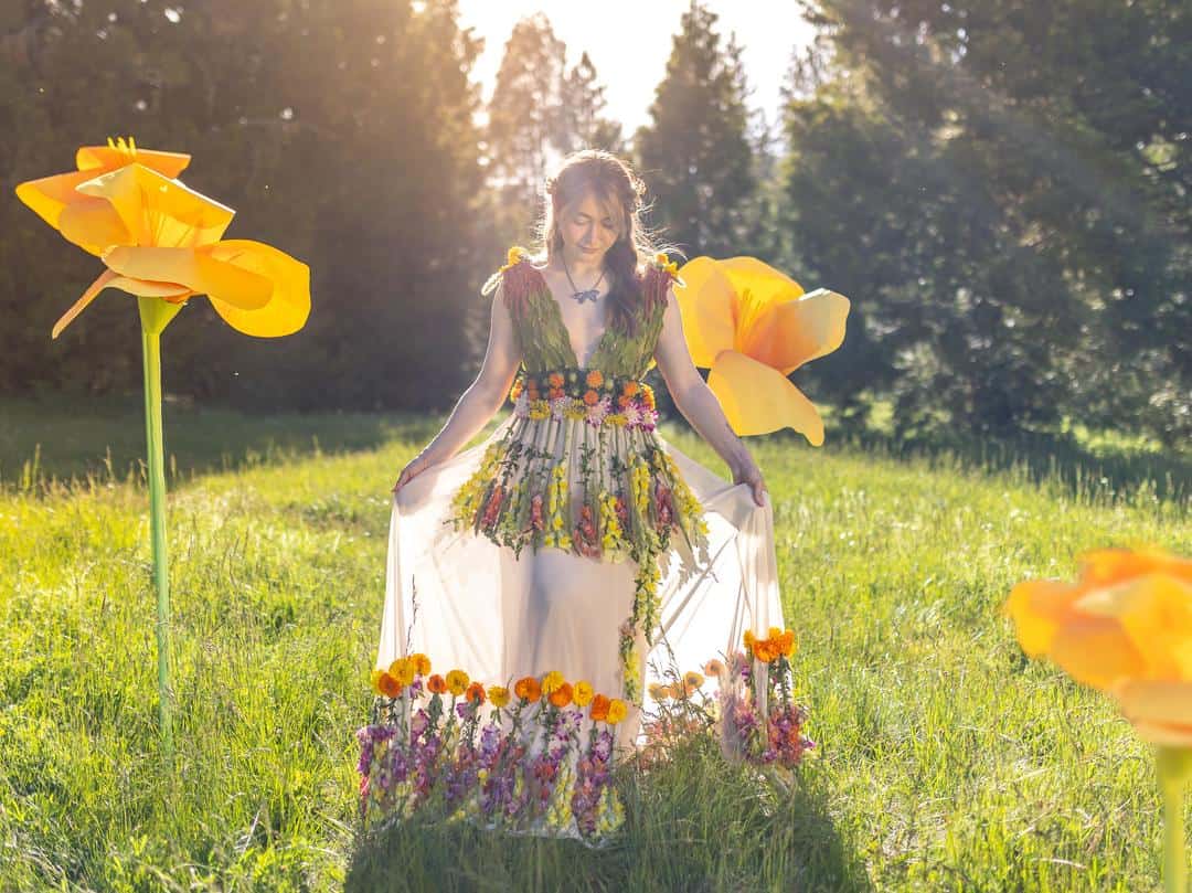 girl in a flower dress walking through a sunny meadow