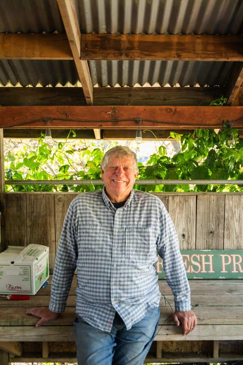 Larry Thorne from Thorne Family Farm leaning against a table in his farmstand in malibu California