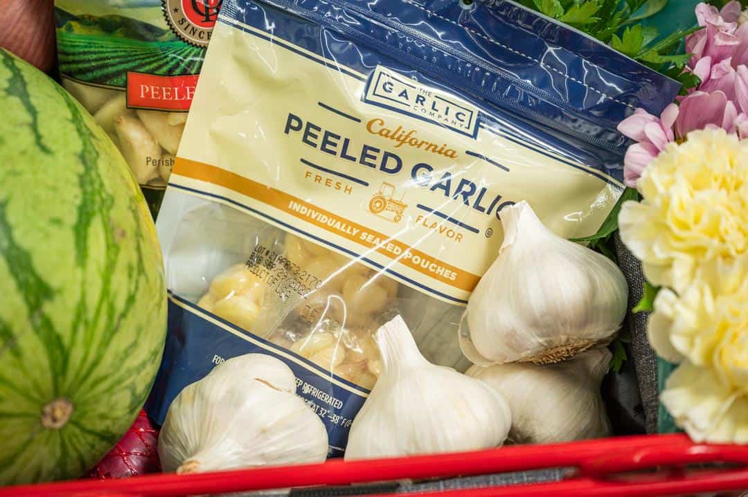 Garlic, both fresh and peeled, in a shopping cart
