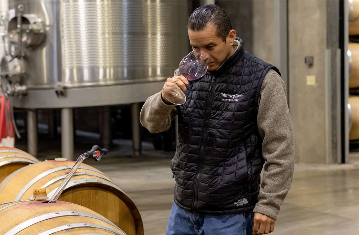 Vintner barrel tasting wine at a California winery