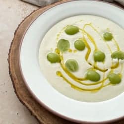 ajo blanco summer soup garnished with green olives and olive oil