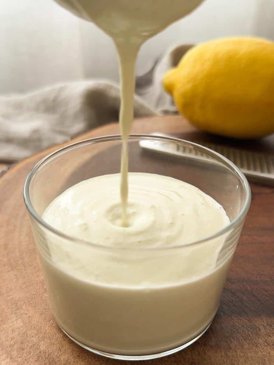 pouring a white creamy soup into a glass