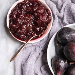 A bowl of fresh fig and blackberry chutney next to a bowl of fresh figs.