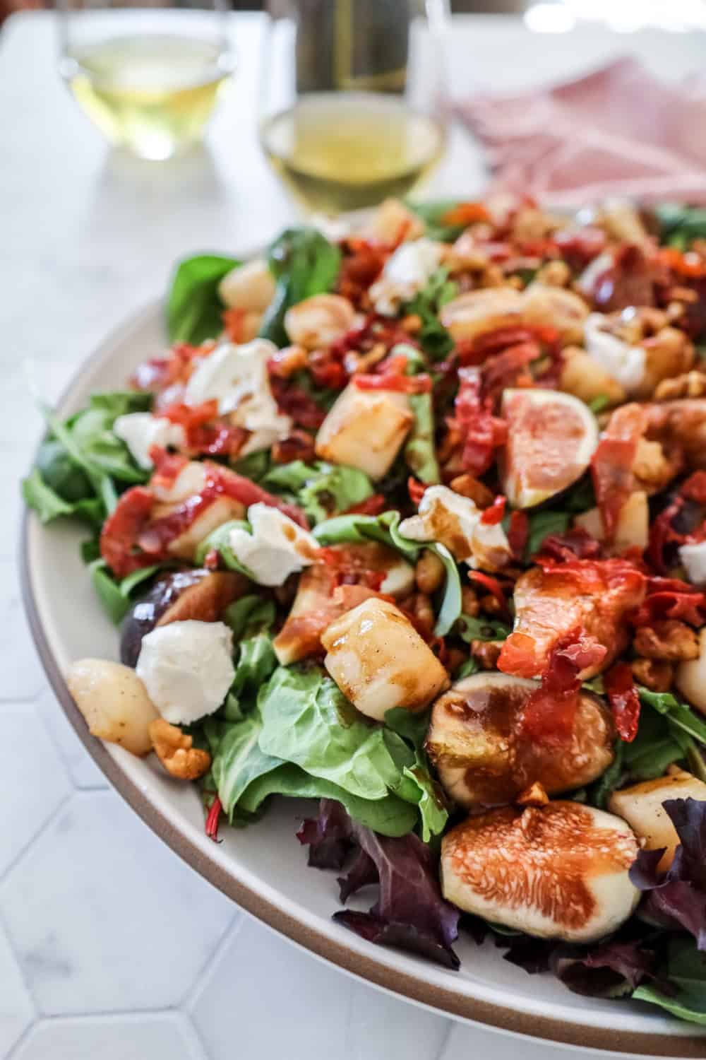 fig and scallop salad with arugula and balsamic in a large white bowl