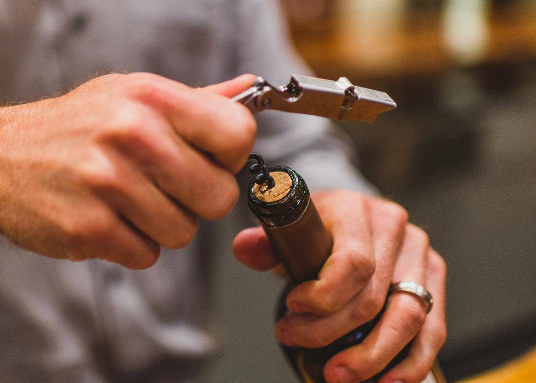 using a corkscrew to open a bottle of wine