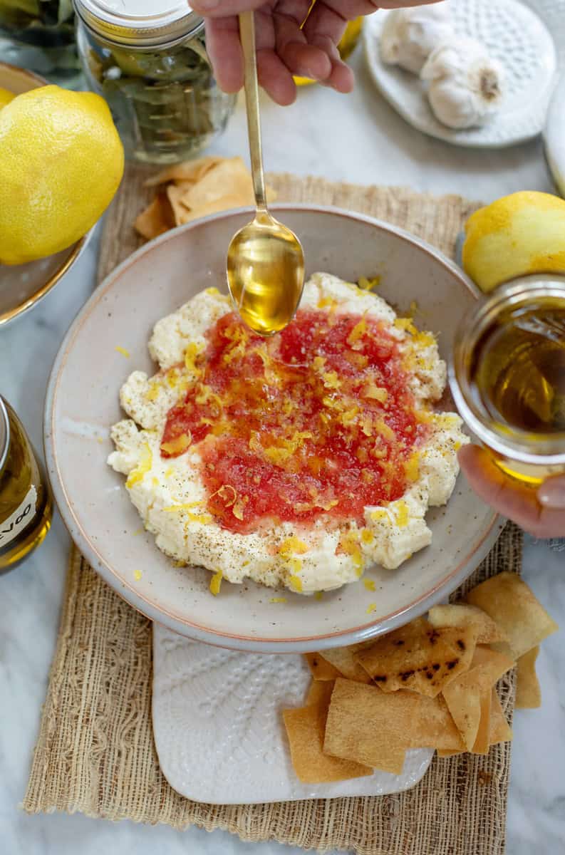 drizzling infused lemon olive oil over cheese and grated tomatoes