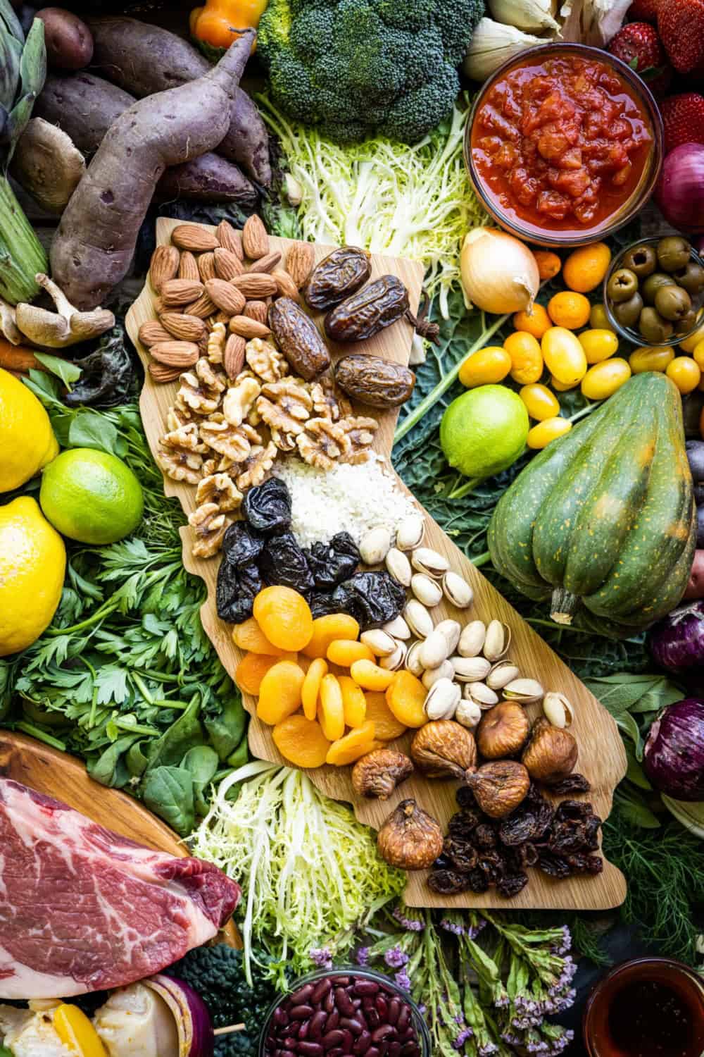 a cutting board shaped like california covered in fruits and nuts