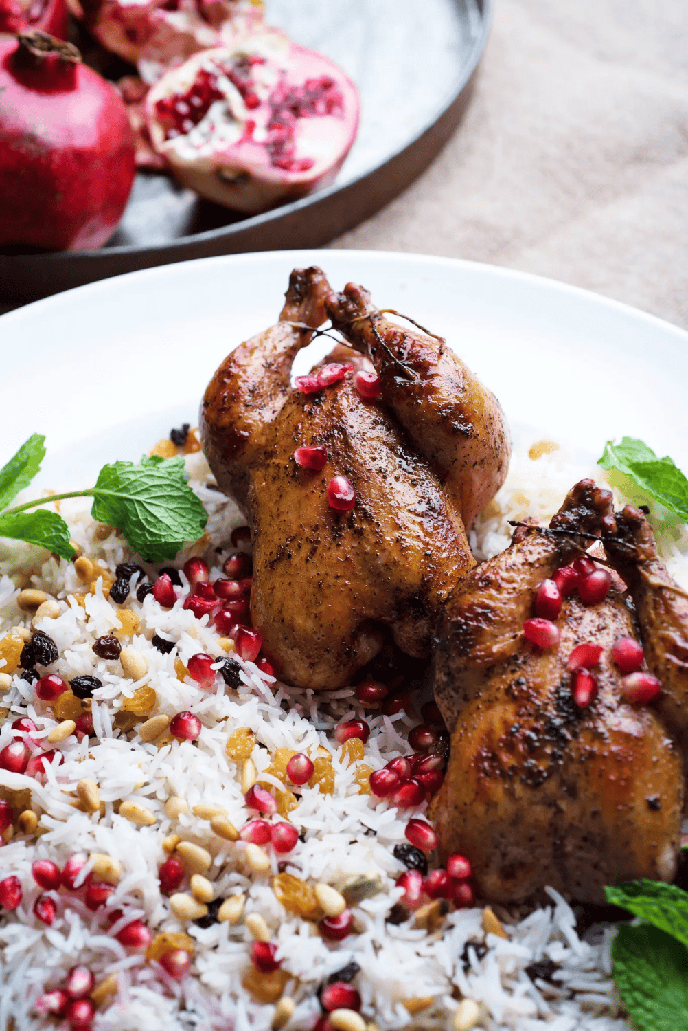 cornish game hens on a white platter with pomegranate glaze