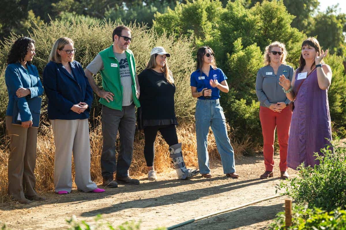 a group of people getting a tour of the fields at the center for land based learning