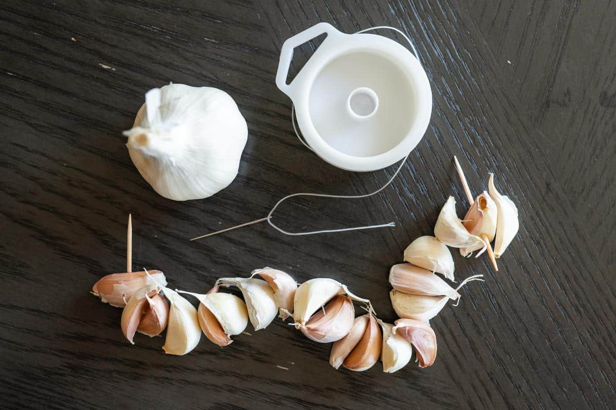 sewing garlic together to create a garland