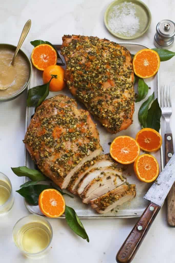 citrus roasted turkey breast garnished with fresh clementines on a white platter