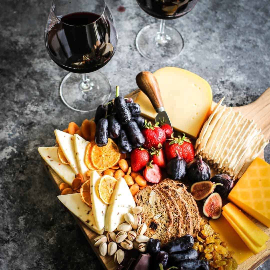 graze board with cheeses, fresh fruit, crackers and wine