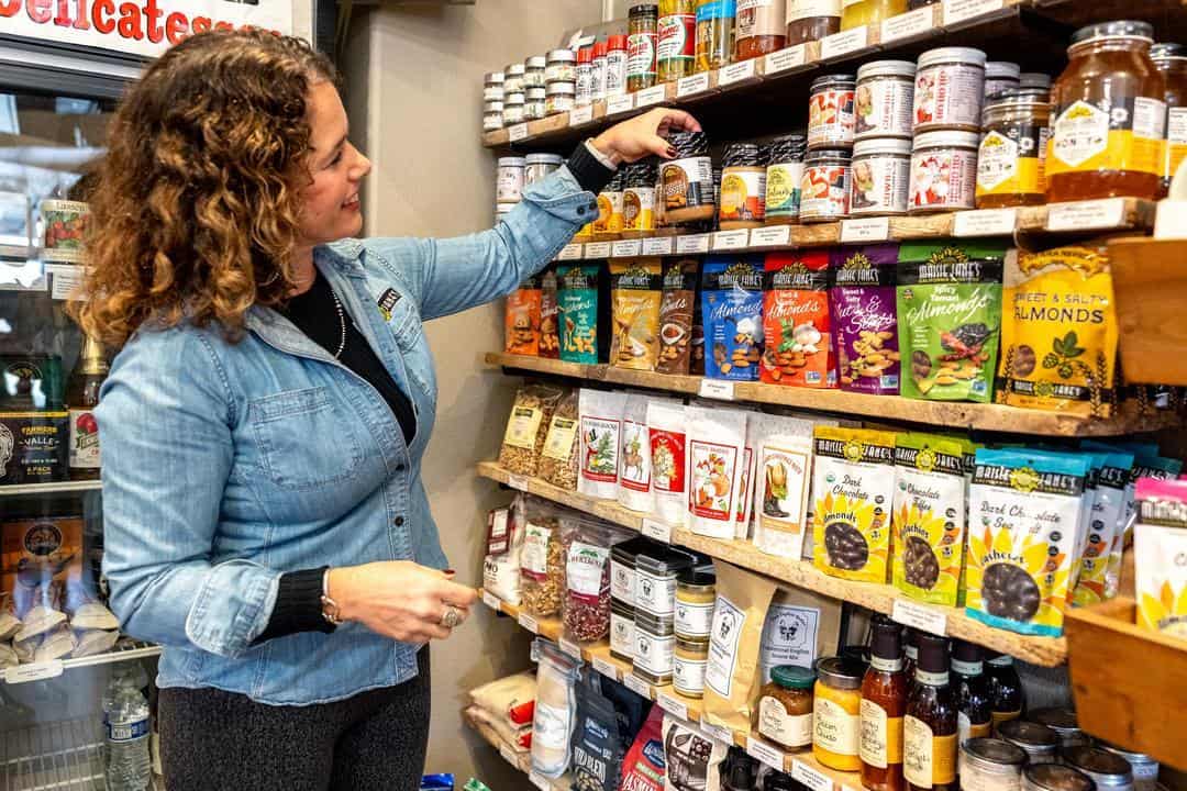 Maisie Jane Hurtado inspecting the items on the shelves of her Chico gift shop